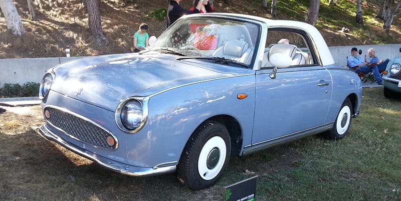 A classic light blue convertible car with whitewall tires on display.