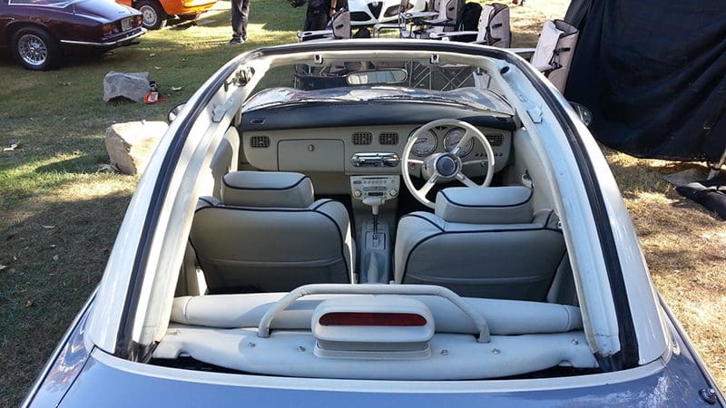Interior view of a white convertible car with modern dashboard and leather seats.