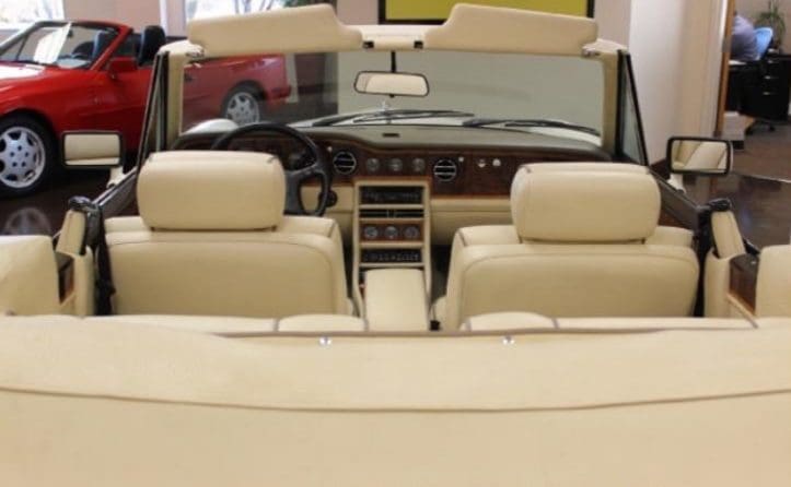 Interior view of a beige leather convertible car.