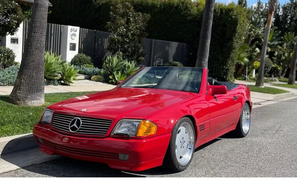 Red Mercedes convertible parked on a sunny driveway.