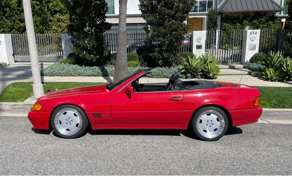 Red convertible sports car parked on street with top down.