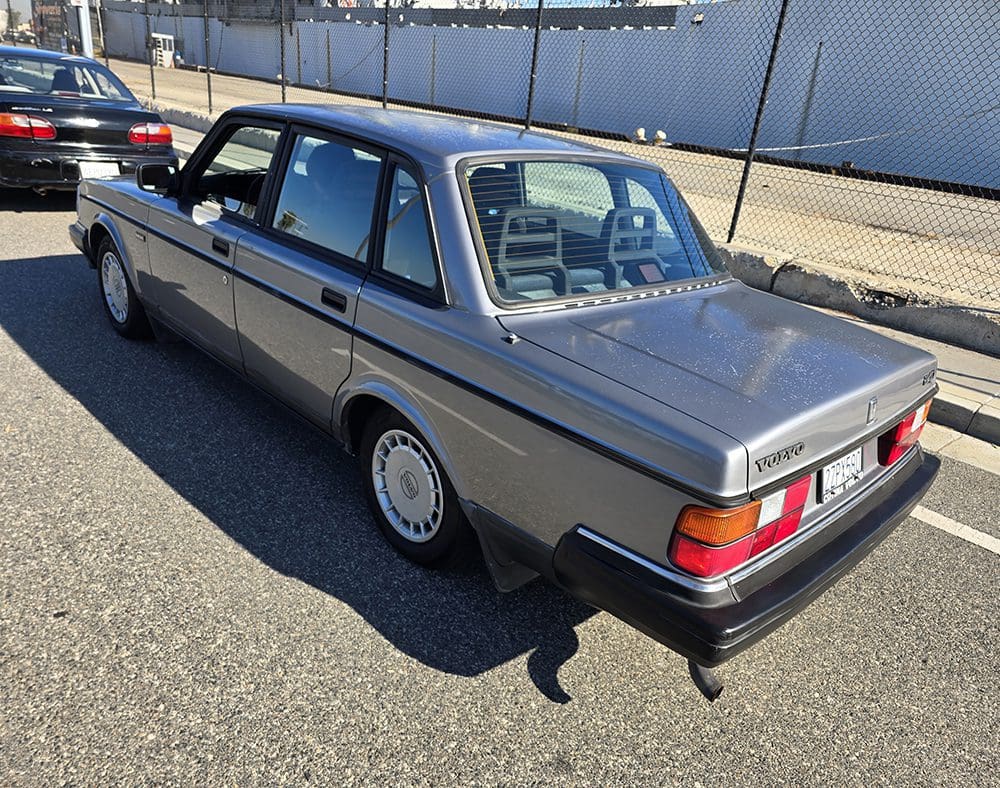A classic silver sedan parked on a sunny street.