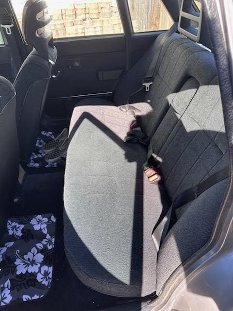 Interior of a car showing the back seat with a seatbelt.