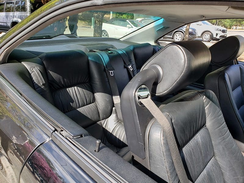 Luxurious black leather car interior with spacious rear seats.