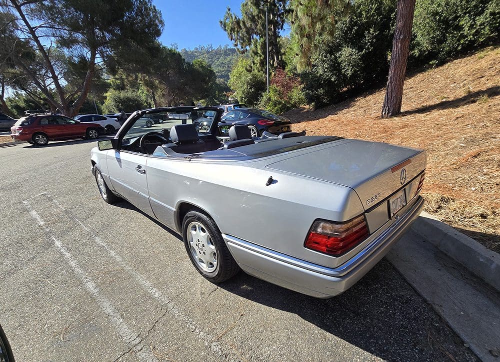 Silver convertible car parked on a sunny day.