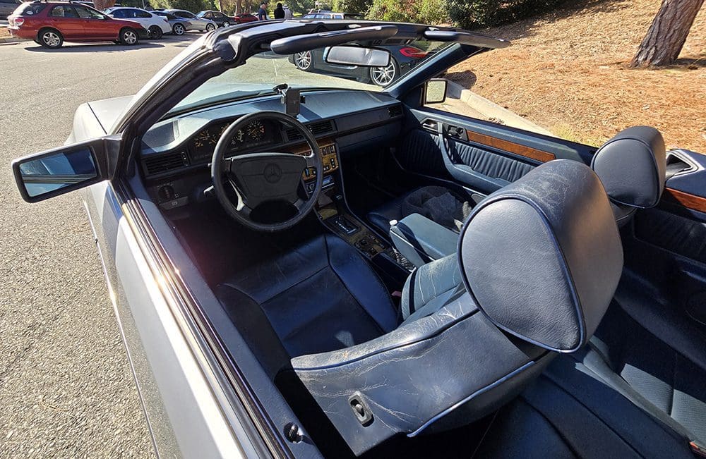 Interior of a classic convertible car with blue seats and dashboard.
