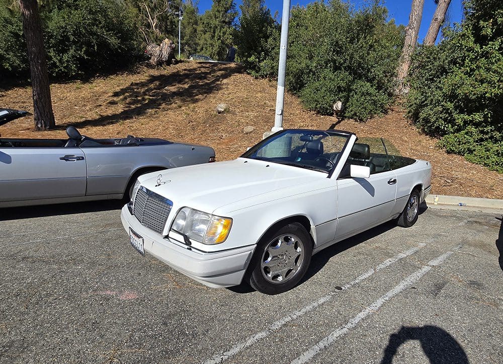 White convertible Mercedes-Benz parked outdoors on a sunny day.