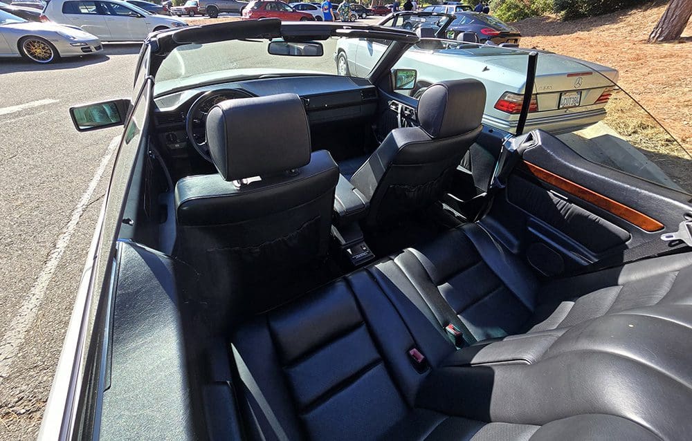 Interior of a convertible car with black leather seats.