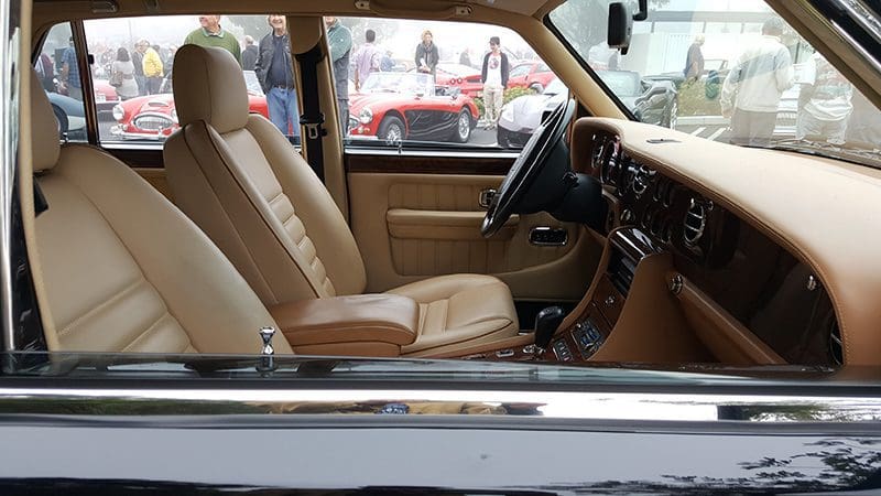 Interior view of a vintage car with tan leather seats and classic dashboard.