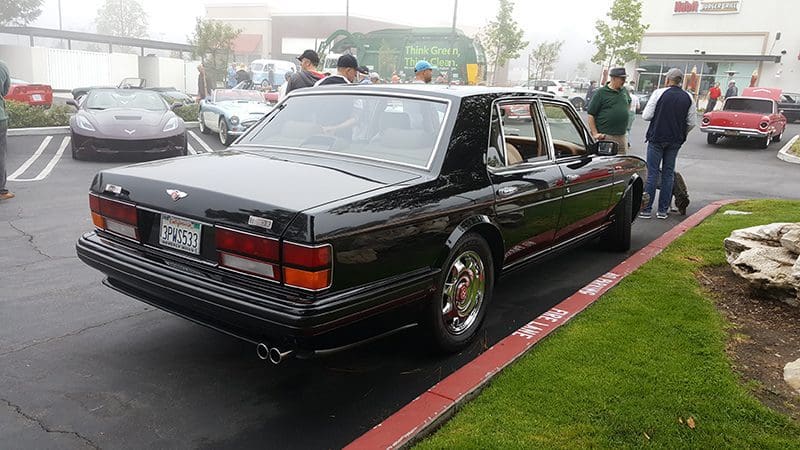 Classic black luxury sedan parked on the street with chrome details.