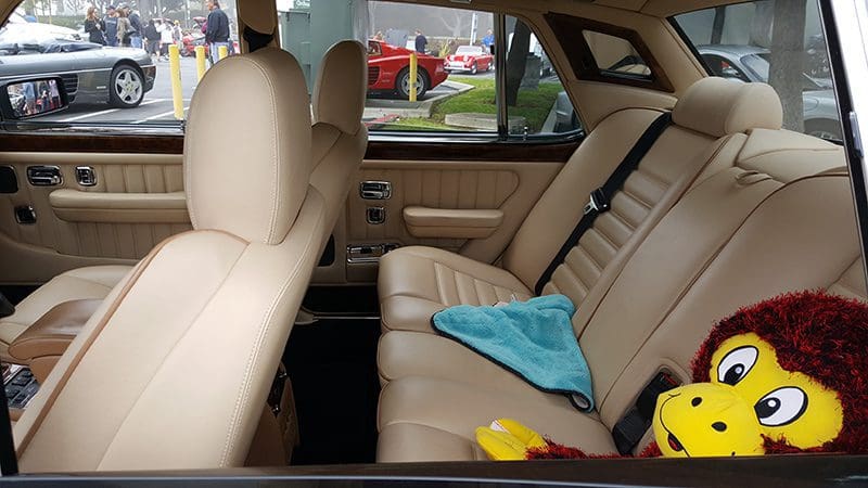 Clean beige car interior with microfiber cloth on back seat.