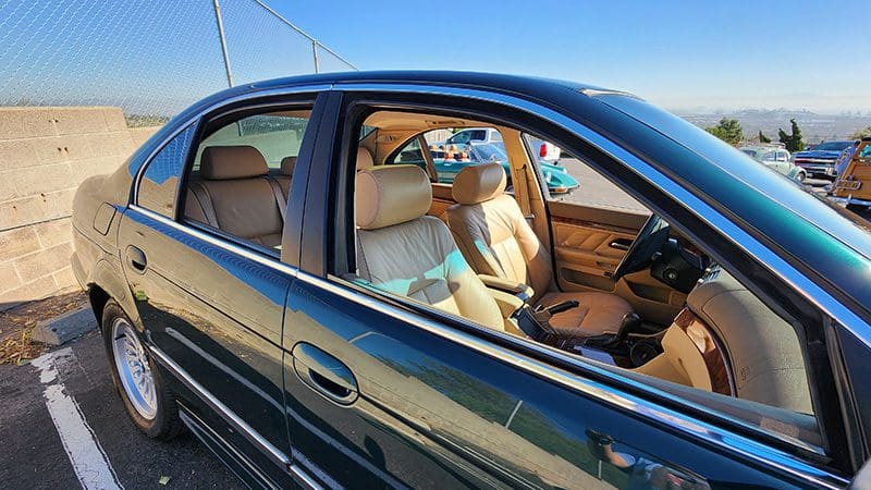Interior view of a car with tan leather seats and a clear sunny sky.