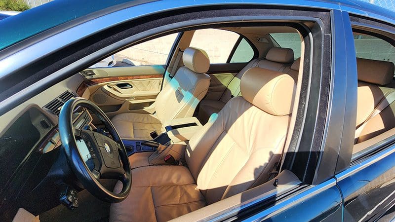 Luxury car interior with beige leather seats and modern design.