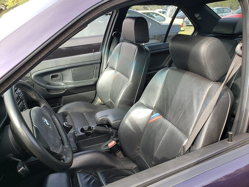 Interior view of a car showing black leather seats and dashboard.