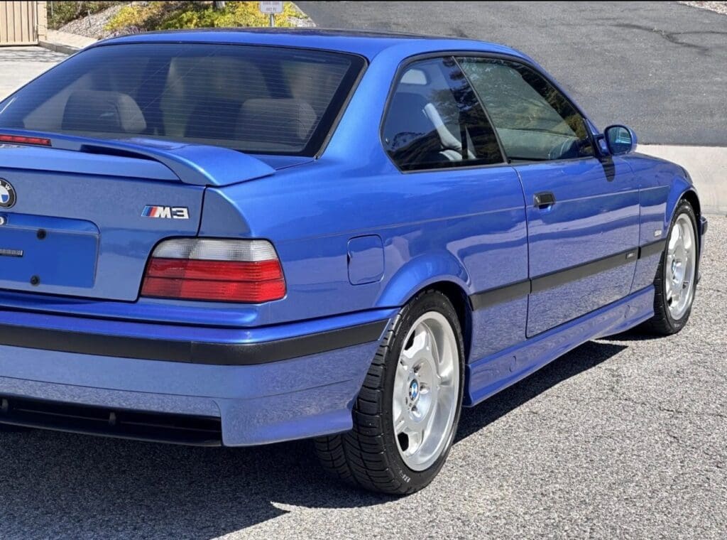 Blue BMW M3 parked on the street in daylight.