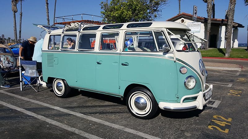 Vintage turquoise and white camper van parked.