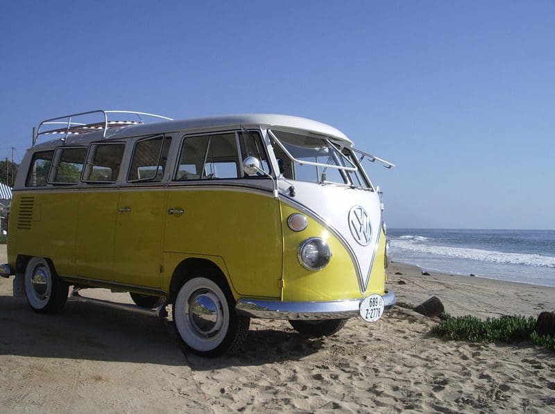 Yellow vintage van parked by the beach.