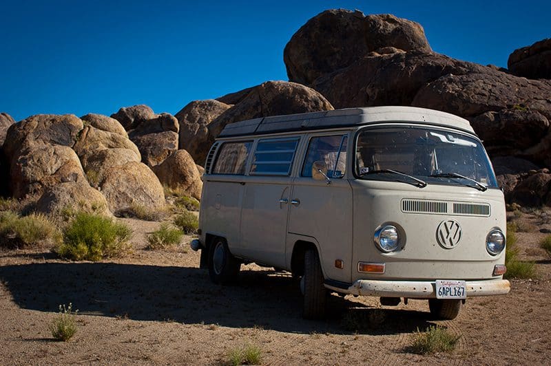 Retro van parked in rocky desert landscape.