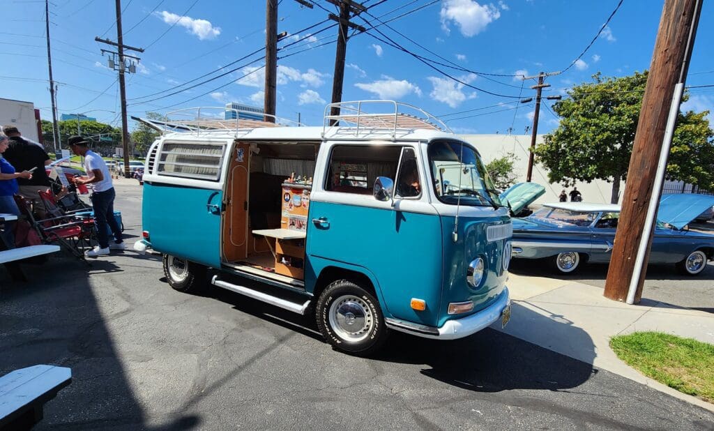 Vintage blue van parked under clear sky.