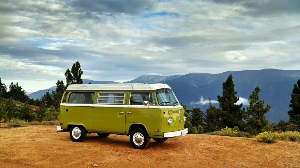 Green van parked on mountain overlook.